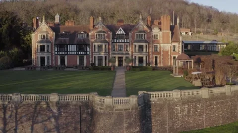 Aerial moving from right to left behind stone wall in front of Wood Norton Hall 스톡 동영상 284247403