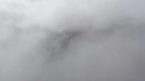 Aerial moving through a cloud to reveal a serene view of mountainous rain forest 스톡 동영상 284249910