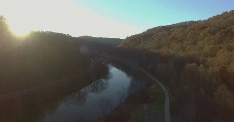 Aerial of Moving Train on Forest River Bend with Sunlight Stock Footage 82733969