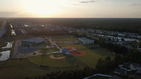 Aerial of multiple baseball fields near suburban neighborhood with the sunset. 스톡 동영상 128913052