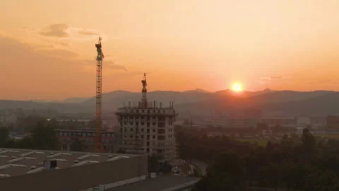 AERIAL: Multistory building under construction is illuminated by the morning sun Stock Footage 135082246