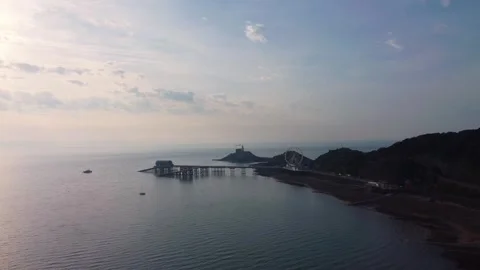 Aerial of Mumbles Pier and Lighthouse at Sunrise. Golden Morning Light Over Bay. Stock Footage 334257466