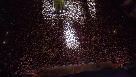 Aerial night shot of a crowd of people attending a music concert Stock Footage