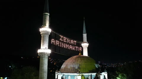 Aerial night view of Eyup Sultan Mosque. There says "Alms is purified." Stock Footage 135514957