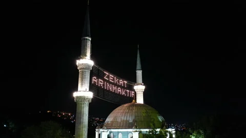 Aerial night view of Eyup Sultan Mosque. There says "Alms is purified." Stock Footage 135539251