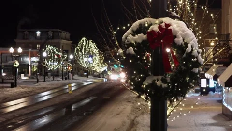Aerial night view of small American town street decorated for Christmas, with Stock Footage 328599307
