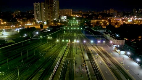 Aerial night view of train station, trains slowly moving from platforms, cars Video stock 113529522