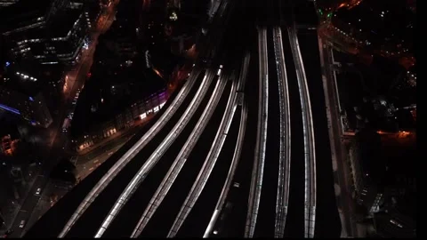 Aerial night view of train station, trains slowly moving from platforms, cars Stock Footage 131967344