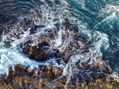Aerial ocean texture. Turquoise waves from above. Crashing surf on rocks. Drone Stock Photos