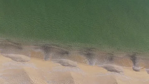 Aerial Ocean Waves Rolling onto Sandy Beach at Golden Hour Stock Footage 325292049