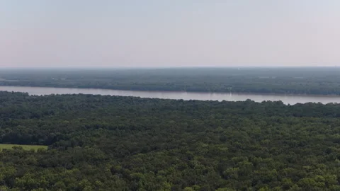 Aerial of Ohio river through dense forest near Metropolis Illinois hazy skies Stock Footage 343592840