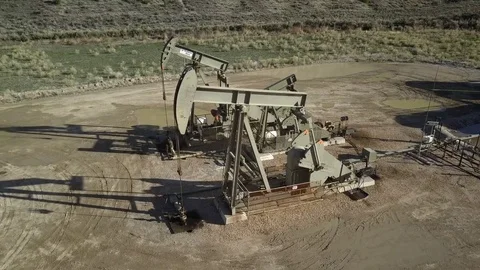 Aerial oil wells pumping high mountain valley Utah 4K Stock Footage