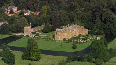 Aerial of old castle surrounded by trees and lawn garden, Broughton Castle Stock Footage 108588839