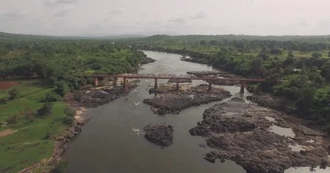 Aerial old rust metallic bridge over large river countryside in Guinea conakr Video stock 82399102