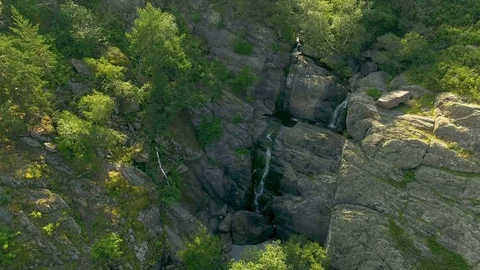 AERIAL: Opening of cascade waterfall in wild nature - rocky mountains with trees Stock Footage 78032033