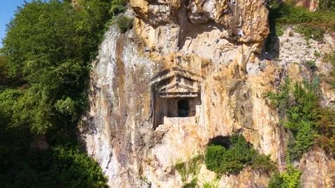 Aerial Orbit Around Ancient Cliffside Royal Tomb with Birds Passing By Stock-Footage 340469016