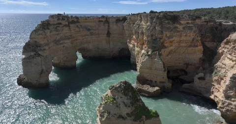 Aerial orbit around double sea arch at Praia da Marinha Algarve Stock Footage 346610321
