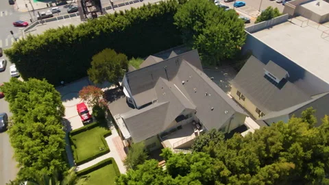 Aerial orbit around a large white house with tall hedges Stock Footage 345708215