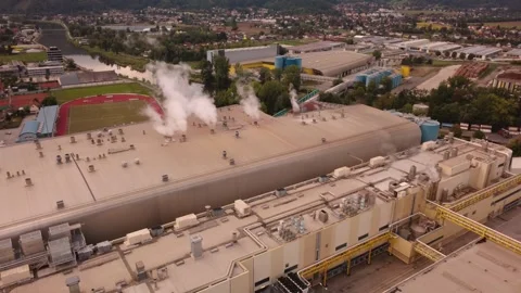 Aerial orbit around a paper mill machine hall venting steam, Austria 動画素材 344693339