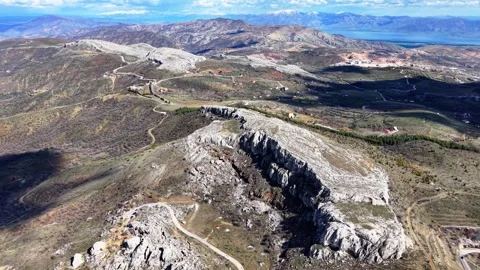 Aerial Orbit Around Rock Formations and Caves With Snow Capped Mountains Stock Footage 342030183