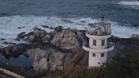 Aerial Orbit Around Small Lighthouse on Rocky Coast at Dusk Stock Footage 340285152