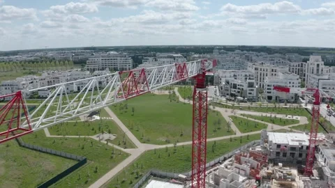 Aerial orbit around a tower crane above a residential construction site, ending Stock Footage 336286818