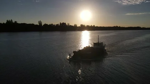 Aerial orbit of backlight cargo ship in Amazon River with sun shining at the Vídeo Stock 151740437