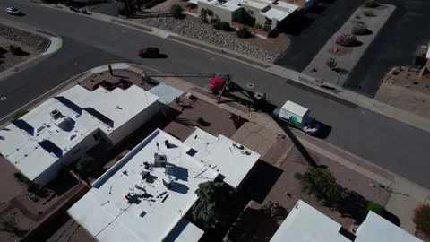 Aerial orbit of a crane setting a rooftop air conditioner unit Stock Footage 206438468