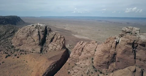 Aerial orbit of deep notch cut into highway 89 rock high over Arizona desert Stock Footage 119120409