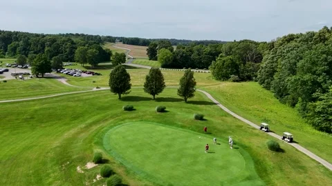 Aerial Orbit Drone Shot of Golf Players on Green Near Winding Path Stock Footage 337637859