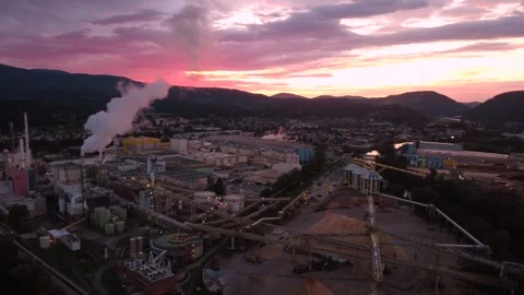 Aerial orbit over a paper mill at sunrise with dramatic pink sky, Austria Stock Footage 344650636