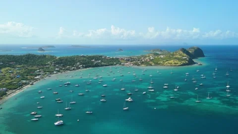 Aerial orbit shot across Tyrell Bay where yachts rest on turquoise Caribbean Stock Footage 343334644