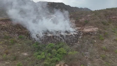 Aerial orbit shot of massive burning landfill and toxic smoke Stock Footage 340921531