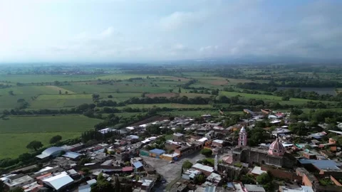 Aerial orbit of a small town surrounded by green fields Stock Footage 342061765