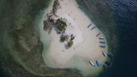 Aerial orbit top down view on small private paradise island with tourist boats Stock Footage 129058831