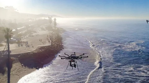 Aerial orbit view from above of two large drones hovering on sunny day. Stock Footage 87188548