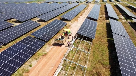 Aerial orbit view of solar installation and offloading using a tractor at Stock Footage 296783431