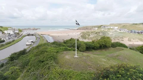 Aerial orbital of the Cornish Flag flying in Bude, Cornwall, highlighting Stock Footage 279968098
