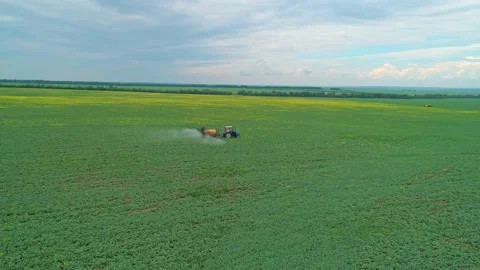Aerial orbital panoramic view of a tractor machine spraying the field with Video stock 197059025