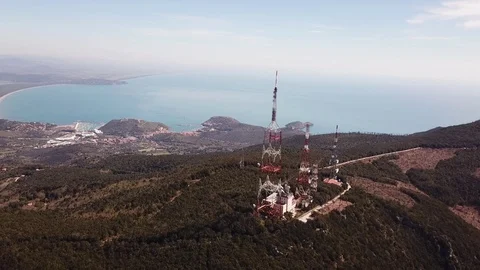 Aerial orbital view, trellis structures on a peak with the seacoast at  distance Stock Footage 105239802