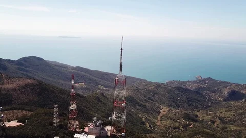 Aerial orbital view, trellis structures on a peak with the seacoast at  distance Stock Footage 105239867