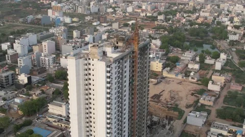 Aerial orbiting shot of under construction skyscraper with crane and workers Stock Footage 197014223