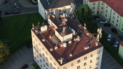 Aerial orbiting view of a building rooftop with 5g cell towers and antennas Vidéo 347873584