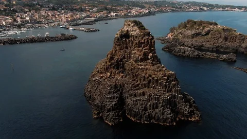 Aerial orbiting view of the faraglioni and the village of Acitrezza, Sicily Stock Footage 113674471