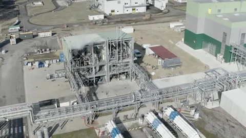 Aerial orbiting view over industrial unit with steam and tankers, France Stock Footage 310334775