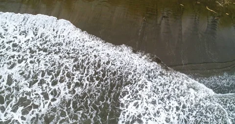 Aerial Over Beach Surf Waves Making Designs On The Dark Sandy Beach By Jungle Stock Footage 135286723