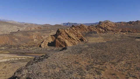 Aerial-Over black basalt cliff to sandstone upthrust Stock Footage 302323331
