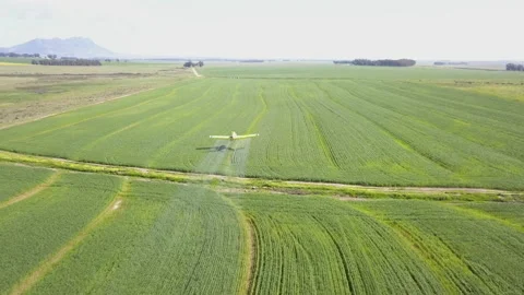Aerial over crop duster plane spraying a field Stock Footage 166573600