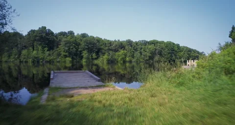 Aerial over dock towards tree line on water Stock Footage 54709841