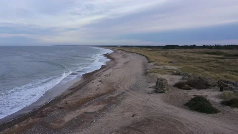 Aerial Over an Empty Beach on an Overcaste Day. Waves Are Crashing to the Shore Stock Footage 201323282